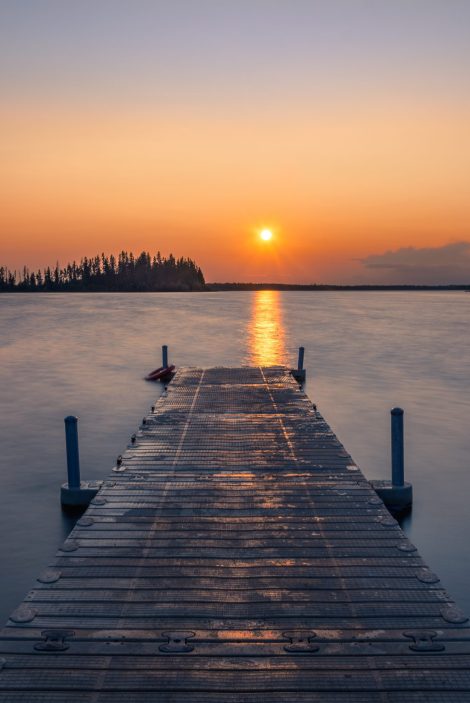 An empty wooden dock  in a lake during a breathtaking sunset- a cool background